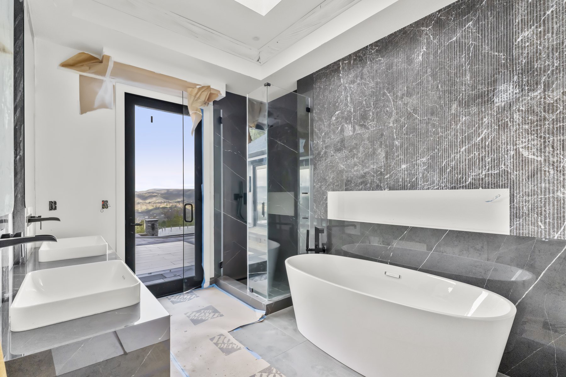 Finished bathroom with glass shower and modern fixtures by Prime Time Plumbing